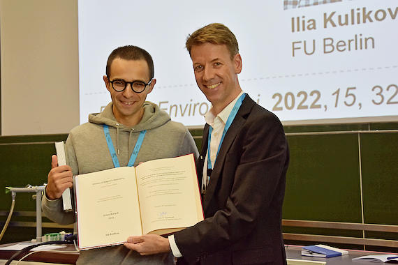Dr. Karsten Seidel (Vorstand der Fachgruppe "Magnetische Resonanzspektroskopie", BASF SE) verleiht Ilia Kulikov den Ernst-Preis der GDCh von 2023