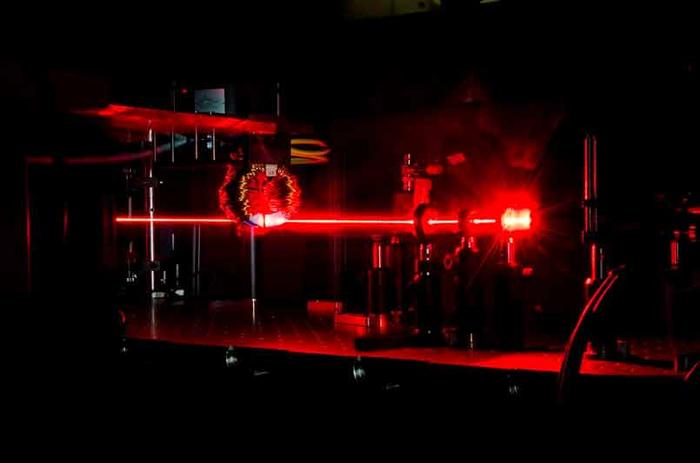 Ein Strahl von Femtosekunden-Laserimpulsen regt extrem schnelle Prozesse in einem magnetischen Material an. @ AG Kampfrath