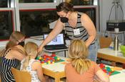 MINToring-Koordinatorin Janina Richter macht mit Mädchen ein Programmierspiel
