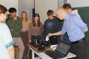 Prof. Dr. Tobias Kampfrath führt Schüler*innen ein "optisches Mikrophon" vor.